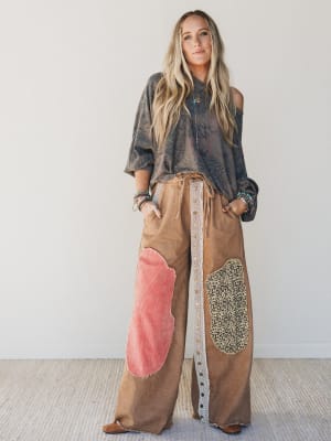 Woman wearing a patchwork pants outfit with a plain background
