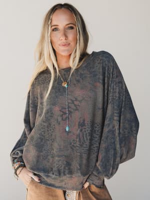 Woman wearing a dark patterned sweater against a plain background