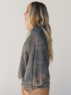 Woman wearing a patterned sweater against a plain background