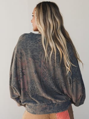 Person wearing a patterned sweater with a neutral background