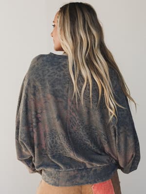 Person wearing a patterned sweater with a neutral background