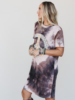 Woman wearing a tie-dye dress with a plain background
