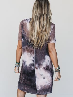 Person wearing a tie-dye dress with a neutral background