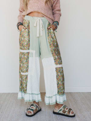 Person wearing colorful patchwork pants with a plain background