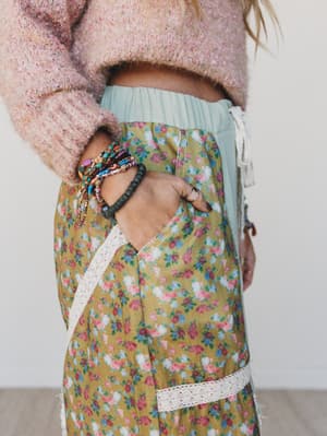 Person wearing a floral apron with a plain background