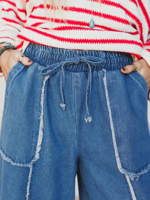 Person wearing a red and white striped sweater with blue jeans.