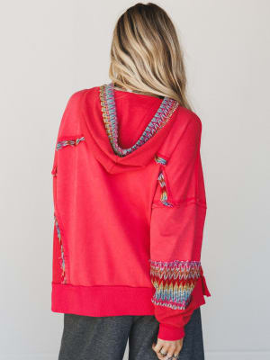 Red hoodie with colorful patterns on a plain background