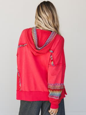 Red hoodie with colorful patterns on a plain background