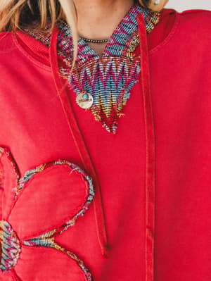 Red hoodie with colorful heart designs and patterns
