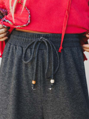 Person wearing a red top and gray sweatpants with drawstring