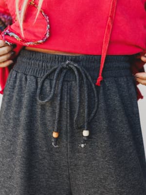 Person wearing a red top and gray sweatpants with drawstring