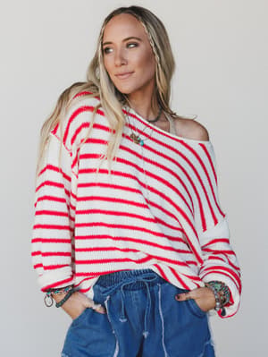 Woman wearing a red and white striped sweater with a neutral background