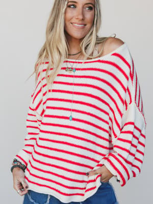 Woman wearing a red and white striped sweater against a plain background