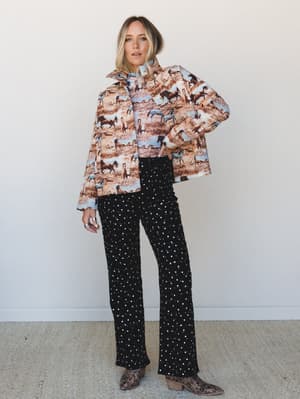 A bold mix-and-match moment — horse-print quilted jacket layered over a matching top, paired with black sequin wide-leg pants and leopard ankle boots for a look that somehow makes total sense.