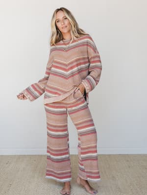 A relaxed matching two-piece set in a warm multistripe waffle-knit texture — the kind of outfit that looks like you tried just enough, worn barefoot with layered gold necklaces and a hand in your pocket.