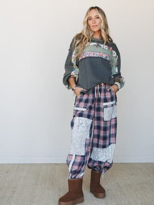 A relaxed, expressive outfit pairing a patchwork floral-and-solid sweatshirt with plaid cargo pants trimmed in lace — the kind of put-together-but-cozy look that feels intentional without trying too hard.