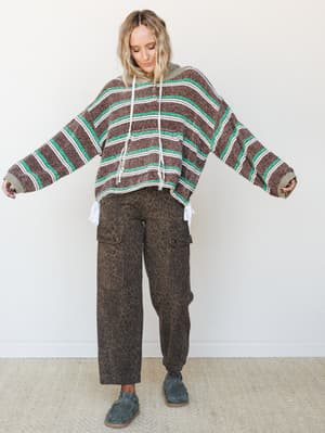 An oversized striped knit hoodie paired with wide-leg leopard cargo pants — the kind of effortlessly mixed-print outfit that looks like it came together on purpose, in the best way.