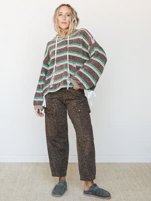 A relaxed, mix-print outfit pairing an oversized striped hoodie sweater with dark leopard print cargo pants and slate suede clogs — the kind of effortless, personality-forward combo that looks like it took no time but absolutely did.