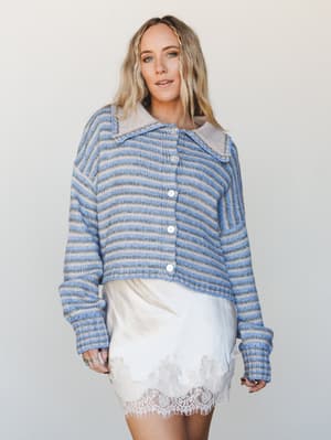 A cozy striped knit cardigan layered over a cream slip skirt with lace hem — the kind of outfit that feels like it was thrown together perfectly, equal parts soft and put-together.