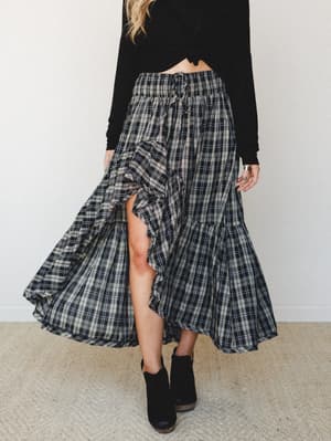 A flowy plaid maxi skirt with ruffle front slit styled with a black cropped long-sleeve top and black ankle boots — the kind of outfit that walks into a farmers market and everyone asks where the skirt is from.