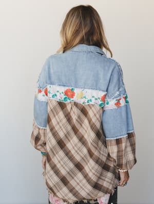 A patchwork shacket shot from the back, mixing light wash denim, a floral stripe, and brown plaid into something that feels like it was pieced together from the best parts of a vintage closet.