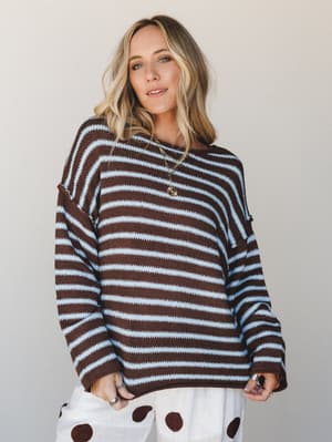 An oversized knit sweater in chocolate brown and sky blue stripes styled with polka dot wide-leg pants — the kind of easy, expressive combo that looks effortless but was absolutely thought about.