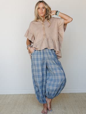 A relaxed, lived-in outfit pairing a washed peplum top with voluminous plaid harem pants — the kind of easy, expressive combo that looks effortless but totally intentional.