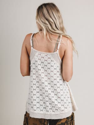 Woman wearing a floral tank top with a neutral background