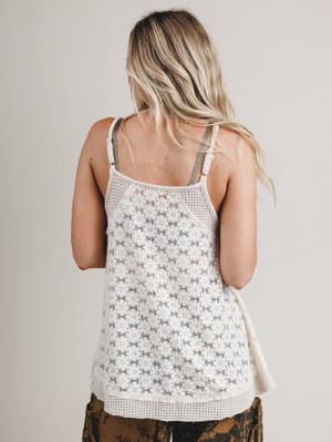 Woman wearing a floral tank top with a neutral background