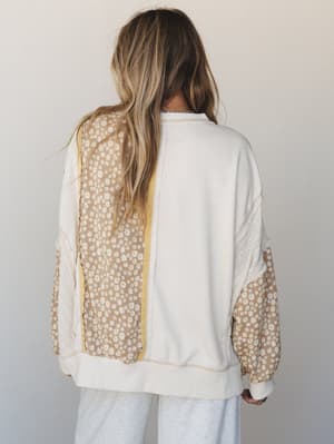 A back-view shot of a mixed-fabric pullover top combining cream waffle knit, daisy floral print panels, and lace trim details — the kind of top that looks like it was made from your favorite things.