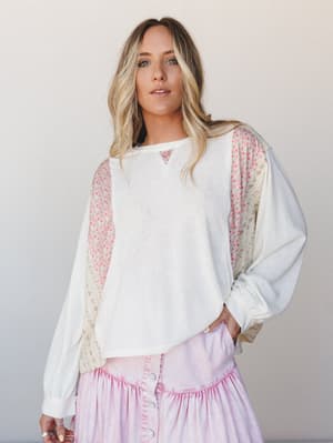 A relaxed long-sleeve top in cream with floral patchwork paneling along the sides and sleeves, styled with a lavender tiered button-front skirt — effortlessly boho and soft enough for a slow Saturday.