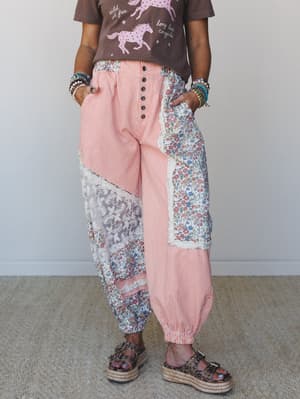 A patchwork-heavy moment — these wide-leg jogger pants mix orange stripe, floral, and lace panels in a way that feels more collected vintage than chaotic, styled with a cowgirl graphic tee and platform espadrille sandals.
