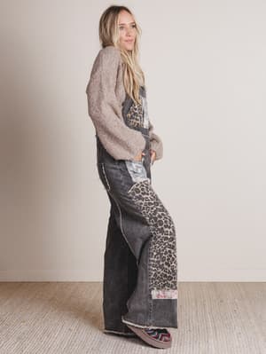 Woman wearing a long, patterned denim dress with a neutral background