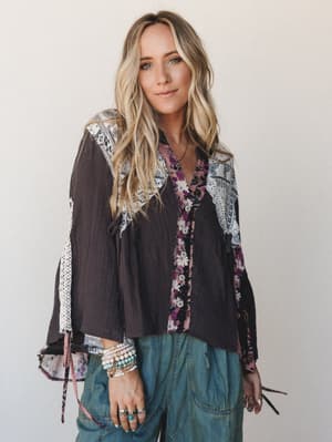 A relaxed patchwork top in charcoal meets floral and paisley panels — styled with wide-leg denim and stacked bead bracelets for that effortlessly collected, free-spirited feel.