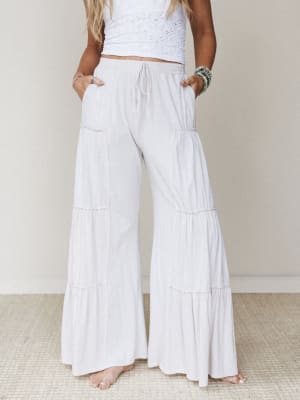 Flowy tiered wide-leg pants in a soft natural white paired with a white eyelet crop top — relaxed, breezy, and the kind of outfit that makes a Tuesday feel intentional.
