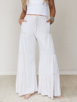 Flowy tiered wide-leg pants in a soft natural white paired with a white eyelet crop top — relaxed, breezy, and the kind of outfit that makes a Tuesday feel intentional.