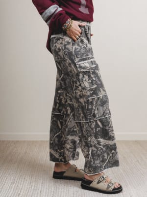 Person wearing camouflage pants with a plain background