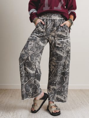 Person wearing camouflage cargo pants and a maroon sweater with a pattern.