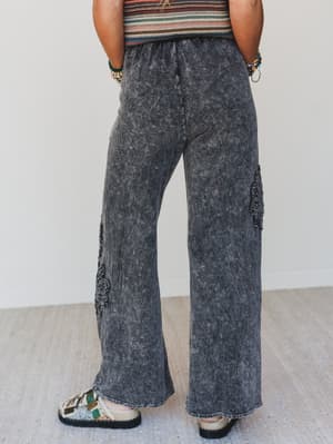 Person wearing acid-wash jeans with a plain background