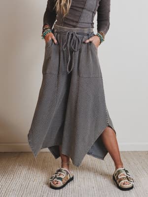 Person wearing a long, striped pants with a neutral background