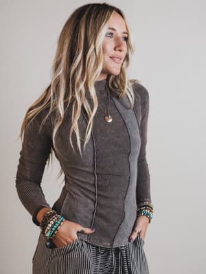 Woman wearing a brown textured jacket with a neutral background