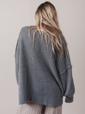 Person wearing a gray sweater from behind on a plain background