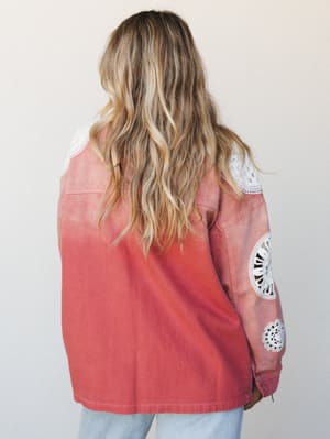 Shot from the back, this washed rust jacket with crochet medallion sleeve details and shoulder panels has an easy, lived-in quality — the kind of piece that makes a simple jeans-and-jacket combo feel like it was thought through.