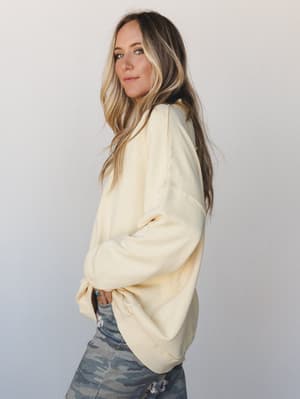 A relaxed, oversized cream sweatshirt paired with camo pants — the kind of effortless layering that looks like you just threw it on and somehow nailed it.