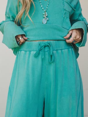 A washed turquoise sweat set styled with layered stone necklaces and stacked silver rings — the kind of matching moment that feels effortless rather than matchy-matchy.