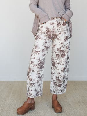 Wide-leg floral barrel jeans in cream and dusty mauve styled with a soft taupe pullover and wooden clogs — the kind of outfit that looks effortless but clearly wasn't an accident.
