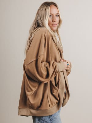 Woman wearing a brown coat against a plain background