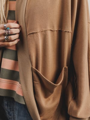 Close-up of a brown jacket with a person wearing it, focusing on the fabric texture.