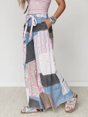 A side-profile shot of a wide-leg patchwork maxi pant styled with a pink lace crop top and beaded sandals — the kind of outfit that looks like it was made from a really pretty vintage quilt, in the best possible way.