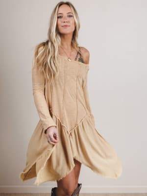 Woman wearing a beige dress against a plain background